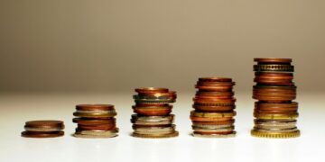 Tumpukan koin yang meningkat tingginya dari kiri ke kanan.